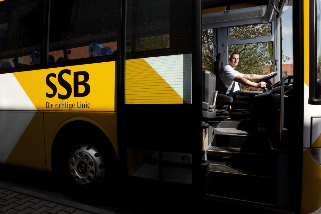 Fahrer im SSB-Bus in Stuttgart, Bus mit gelb-weißem SSB-Branding, Bussteig und Einstieg sichtbar