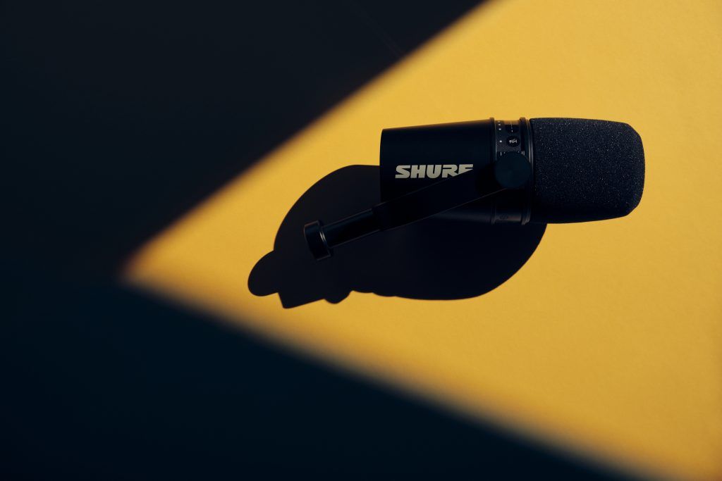 Studioaufnahme eines Mikrofon-Setups mit hochwertiger Lichtführung und Farbverlauf im Hintergrund