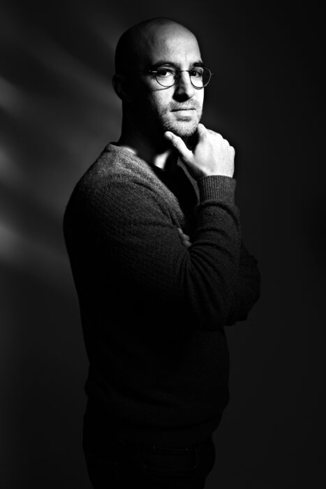 Minimalistisches Portrait im Steve-Jobs-Stil mit schwarzem Hintergrund und klarer Lichtführung