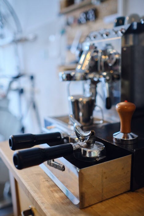 Detailaufnahme einer Siebträger-Espressomaschine in einer Fahrradwerkstatt – Coffee and Cameras Lifestyle Fotografie
